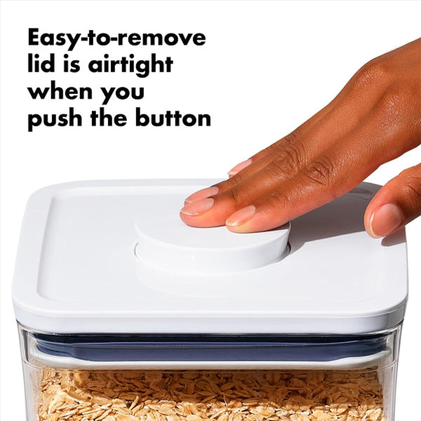 Hand pressing a button on a container with oats, text indicating an airtight lid feature.