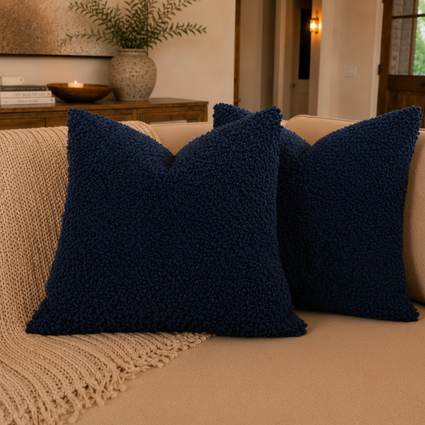 Navy blue textured pillow on a beige couch with a blurred indoor background